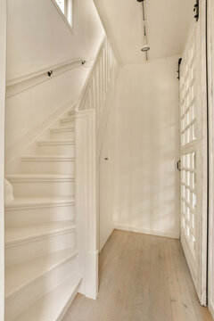 the inside of a house with wood flooring and white painted walls, stairs leading up to the second floor