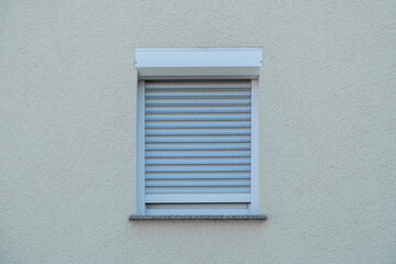closed outdoor blind on a window on a white wall
