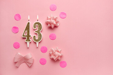 Number 43 on a pastel pink background with festive decor. Happy birthday candles. The concept of celebrating a birthday, anniversary, important date, holiday. Copy space. Banner