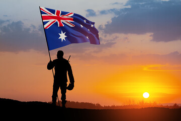 Silhouette of soldier with Australia flag on background of the sunset or the sunrise background. Anzac Day.