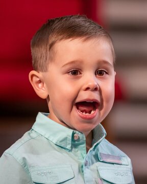 Portrait Of Young Boy On Stage Singing Loudly