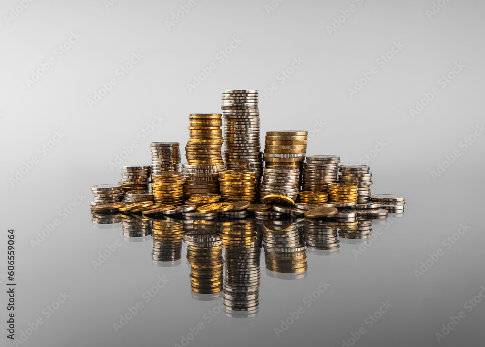 Poster stacks of coins in reflection on a grey background