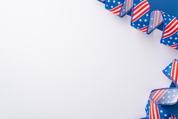 Fourth of July celebration vibes. Top view of symbolic party supplies: curly serpentine with USA flag pattern. Bicolor blue and white background with space for text or advertisement