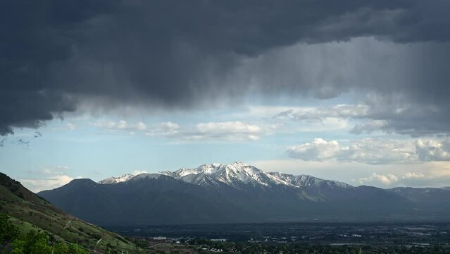 Time lapse of clouds moving over Utah Valley looking at Loafer Mountain in the distance with snow on the peaks.