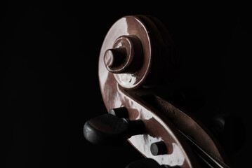 Violin, details of a beautiful violin on rustic wood, low key style photo, black background, selective focus.