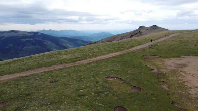 man walking on the mountain alone with dogs with spectacular views