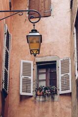 Window and flower in an alley with lamppost