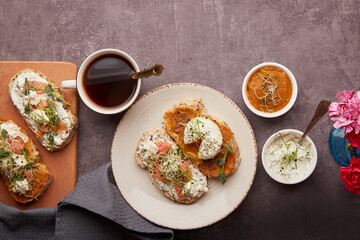 Healthy breakfast - Low-Carb Cuisine with sandwiches with Greek yogurt and zucchini spread, poached egg, salmon, coffee cup. Low in calories, FODMAP diet, superfood