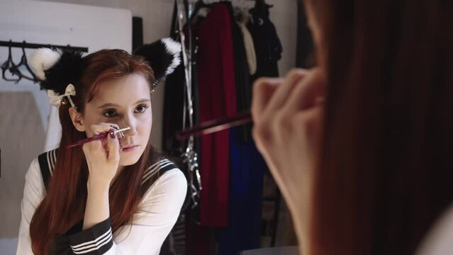 Young woman doing makeup - contouring her nose