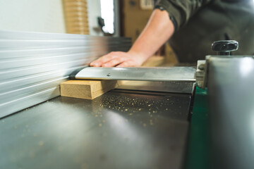 closeup shot of a piece of wood going into the vacuum system in the carpenter's workshop. High quality photo