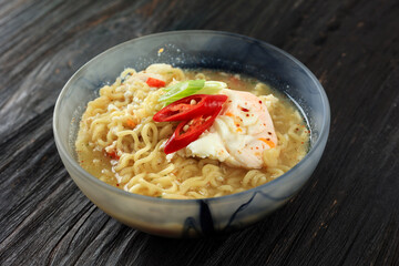 Spicy Instant Noodle Soup with Poached Egg, Green Onion, and Sliced Chilli.
