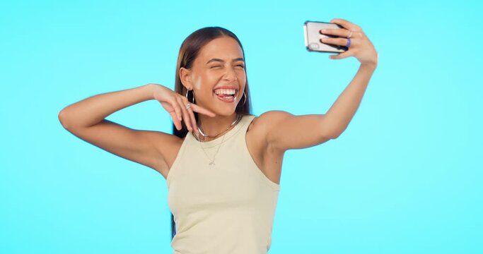 Woman, selfie and happiness with influencer and social media post, memory and carefree on blue background. Mockup space, energy with young female person smile and pose in picture with live stream