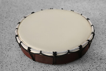Drum on grey table, closeup. Percussion musical instrument