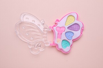 Decorative cosmetics for kids. Eye shadow palette on pink background, top view
