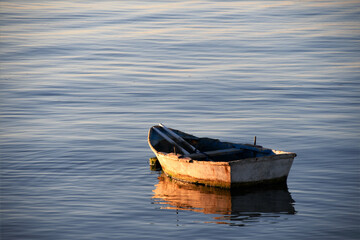 Small boat in the sea at sunset
