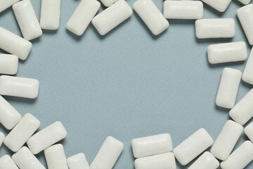 Frame made of tasty white chewing gums on light blue background, flat lay. Space for text