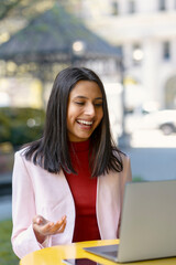 Confident smiling Indian woman using laptop computer, explaining something having video call sitting at workplace. Happy asian student studying, learning language, online lesson, education concept