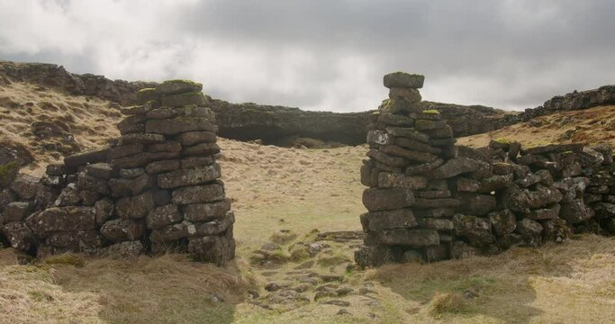 Stone wall entrance to historic sheep farm, Burfellsgja Iceland, sun and clouds