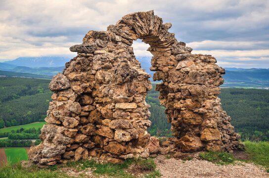 Ancient ruins on a Rockface in Gleissenfeld. Ruins are located in Nature Park Seebenstein-Turkensturz in Austria, with mountains and village in background.