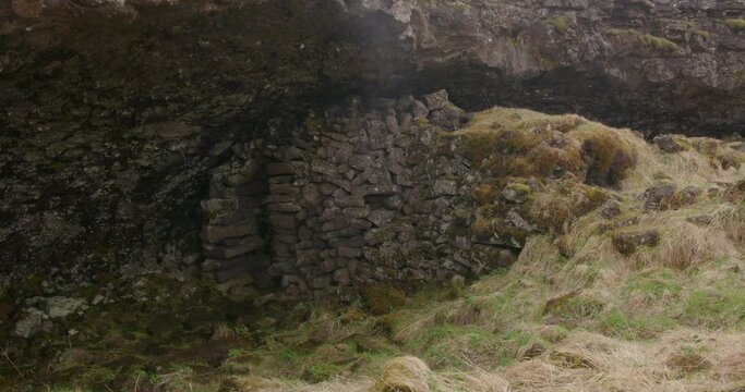 Historic stone house under cave ledge, Burfellsgja Iceland, close up