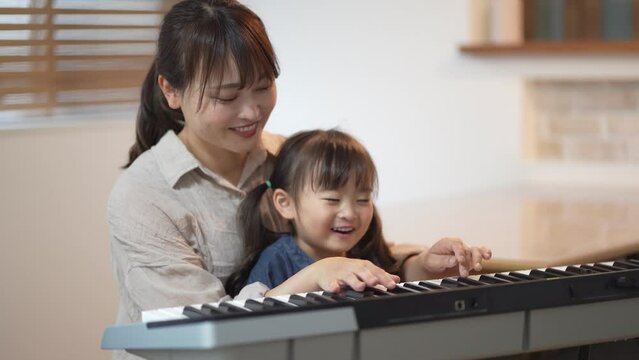 ピアノを弾く練習をする親子