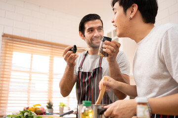 Cheerful Boyfriends gay LGBTQ lovely couple making a drip coffee brew in the kitchen together for breakfast.