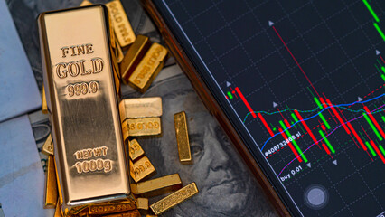 gold bars place on the phone that opens the candlestick chart. and dollar. Fluctuations in gold prices concept.