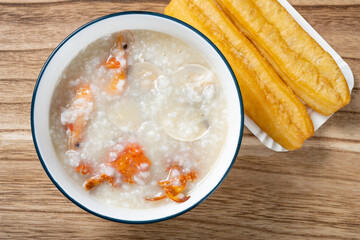 top view seafood porridge with crabs and shrimps and white shells and deep-fried dough sticks horizontal composition - obrazy, fototapety, plakaty