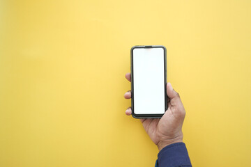 hand holding smart phone with white screen on yellow background 