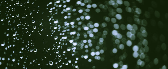Atmospheric minimal monochrome backdrop with rain droplets on glass. Wet window with rainy drops and dirt spots closeup. Blurry minimalist background of dirty window glass with raindrops close up.