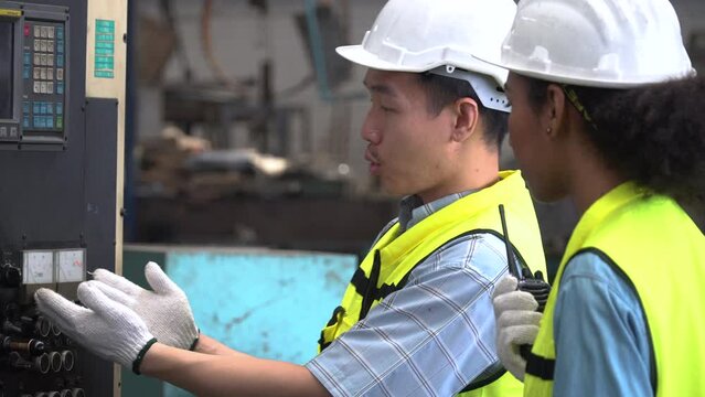 group of diverse african american woman engineer manager quality control checking and inspection with asian worker and machinery in industry factory . Safety check at workplace