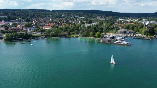 Aerial drone view of yacht on Starnberg See lake, Bavaria Germany. Recreation and relaxation area with beach, cafe and forest.
