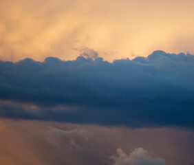 Naklejka na ściany i meble Rain clouds at sunset as background