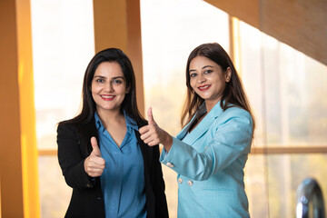 Indian corporate women showing thumps up at office