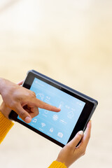 Biracial young man pointing at application on digital tablet and woman controlling smart home