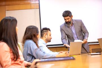 Fototapeta premium Indian businessman explaining project detail in a meeting to his partner or employee.