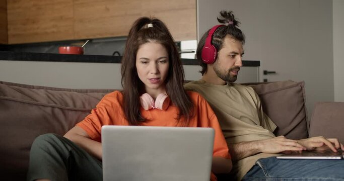 Young Couple Working Together on Laptops at Home