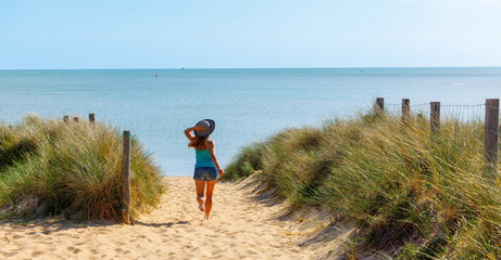 Happy woman on the beach dune- girl running to the sea- vacation,  summer holiday,  freedom,...