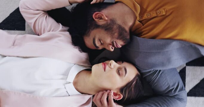 Love, intimate and couple relaxing on the floor rubbing faces, sleeping and bonding in their house. Affection, romance and young man and woman touching with gentle care while laying on a mat at home.