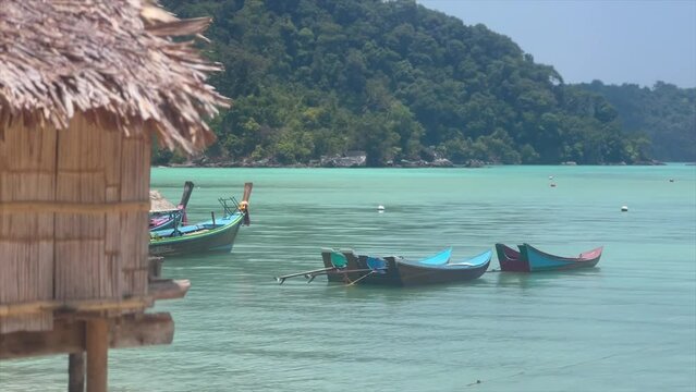 Stilt huts and boats off idyllic beach on Moken island
