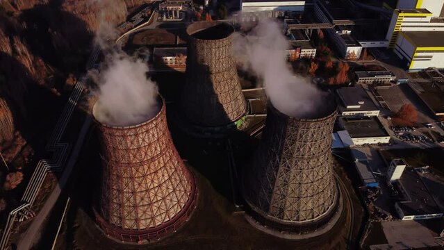 Three chimneys from which smoke comes out. A power plant taken from aerial photography.