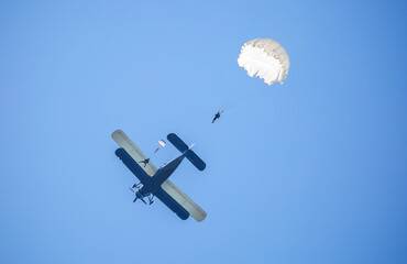 Skydiving. Parachutists jump from a flying plane in the air. Extreme sport and entertainment.