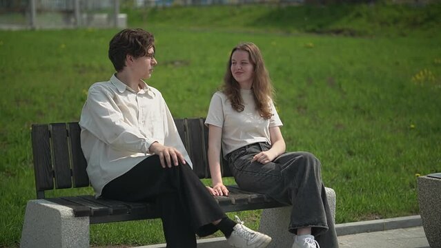 teenagers sit on a park bench. first relationship. slow motion video.High quality Full HD video recording 