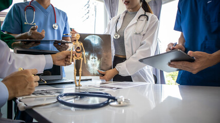 Medical team meeting with doctors in white lab coats and surgical gowns sitting at table discussing patient history. success of medical health care doctor work concept