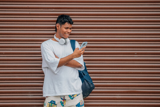 Young Latino Man In The Street Looking At The Mobile Phone