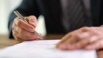 Businessman signing document contract with ballpoint pen in office closeup. Formal employment and contract agreements concept