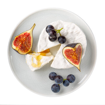 Cheese plate isolated on white background. Brie cheese served with  fruits and honey on gray plate. Top view.