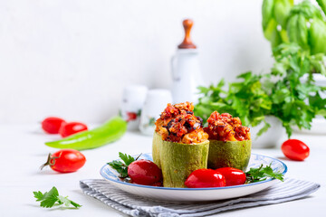 Zucchini stuffed with minced chicken .