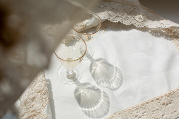 Glasses on a linen napkin, shadows from glasses illuminated by the sun