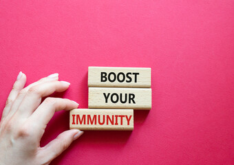 Boost your immunity symbol. Concept word Boost your immunity on wooden blocks. Doctor hand. Beautiful red background. Helthcare and Boost your immunity concept. Copy space